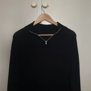 Svart stickad tröja med half zip - Halt zip tröja i färg svart, väldigt fin, tröjan är i väldigt bra skick, 