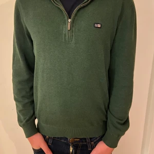 Grön Lexington tröja med half zip - Snygg grön tröja från Lexington med half zip och liten logotyp på bröstet. Tröjan har långärmad design, ribbade muddar och är gjord i mjuk bomull. Perfekt för dig som gillar klassisk stil med en modern touch. Modellen är 168 lång och väger 58 kg, sitter som en xxs. Pris kan självklart diskuteras💯💯