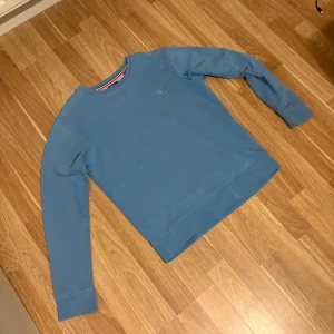 Blå sweatshirt från GANT, 170 cm - Snygg blå sweatshirt från GANT med diskret logga på bröstet. Tröjan har rund hals, ribbade muddar och är tillverkad i mjuk bomull. Perfekt för dig som gillar klassisk stil och vill ha något bekvämt och enkelt att slänga på sig. Tröjan har några fläckar på framsidan så skriv till mig om ni vill se bilder! Pris kan diskuteras!
