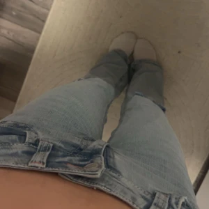 Blåa jeans med hål från nelly - Nytt skick, blåa jeans från Nelly med hål i och rosa detaljer