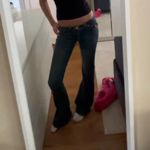 True Religion mörkblå bootcut jeans - Snygga mörkblå jeans från True Religion med klassiska kontrastsömmar och ikoniska fickdetaljer bak. Modellen har låg midja och bootcut. Och dom är som nya