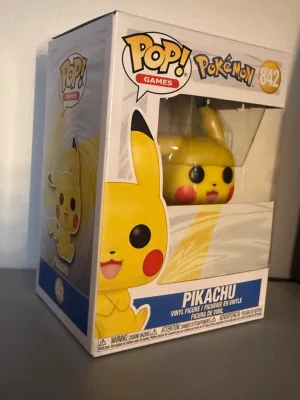 Funko Pop! Games Pokémon Pikachu #842 - Säljer en Funko Pop! Games Pokémon Pikachu #842 vinylfigur i originalförpackning. Figuren är helt ny och oöppnad, med kartongen i mycket fint skick utan synligt slitage. Perfekt för samlare och Pokémon-fans!