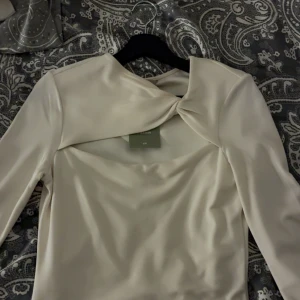 Vit topp  - Säljer en elegant  blus från H&M med lång ärm och snygg knutdetalj vid halsen. Prislappen är kvar o är exakt som ny❤️Köpt för 229 kr