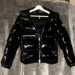 Svart glansig pufferjacka med huva - Svart dunjacka från Colmar🩷💕En väldigt varm och snygg jacka, älskar den verkligen och luvan är helt magisk!💕💕 Den är nästan aldrig använd då ja köpte den sent förra vintern o nu märker att den har blivit för kort i ärmarna så kan inte länger använda den 😔Hör gärna av er om ni har några frågor☺️💕                                                          Jag köpte den för 4800kr men pris går att diskutera💕💕                                            Storlek: S, för åldern ungefär 16+, 172cm 