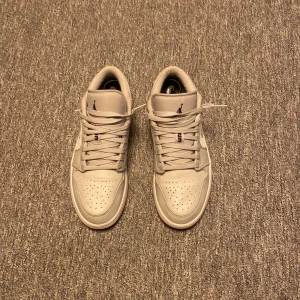 Air Jordan 1 Low White Camo - Säljer ett par Nike Air Jordan 1 Low White Camo i helvitt skinn med diskret camo-mönster på swooshen. Klassisk siluett med rund tå, snörning och broderad Air Jordan-logga på hälen. Perfekta sneakers för dig som gillar stilrena och unika detaljer. Köpta för 10 999 kr. Säljer för endast 1999. Skicka för minsta fundering.