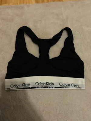Topp Calvin klein - Calvin Klein topp. Använd få gånger men texten har lyckats suddas ut i tvätten. Utöver det toppen!🙌🏼