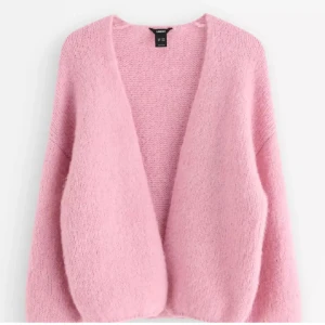 Ljusrosa stickad kofta från Lindex - Supermysig ljusrosa stickad kofta från Lindex med oversized passform och långa ärmar. Koftan är öppen framtill och har en fluffig, mjuk känsla som passar perfekt för lager-på-lager. Enkel att styla till både jeans och klänning.