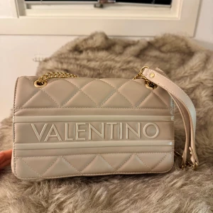 Valentino väska  - Säljer min fina valentino väska som endast är använd fåtal gånger och är i nyskick, den är ljusrosa med guld kedja, dustbaggen tillkommer 