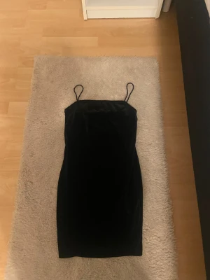 Svart sammetsklänning från Shein - Supersnygg svart kortklänning från Shein i mjuk sammet. Klänningen har smala axelband och en figurnära passform som ger en stilren och modern look. Perfekt för dig som gillar minimalistisk stil och vill sticka ut med en klassisk vibe.