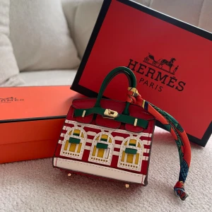 minihandväska med fönsterdetaljer - Superunik minihandväska från  i rött skinn med coola fönsterdetaljer i vitt, gult och grönt. Väskan har grönt handtag, guldfärgat lås och en färgglad scarf knuten runt handtaget. Perfekt statement piece för dig som vill sticka ut.