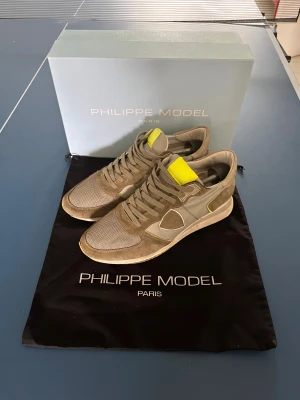 Philippe Model - Snygga sneakers från Philippe Model. Ovandelen är en mix av mocka och mesh, med snörning och rund tå. Sulan är gul och har ett mönstrat grepp. Perfekt för dig som gillar stilrena och sportiga skor med en twist. Går att jobba med priset 