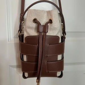 H&M Bucket bag  - Säljer denna sååå populära och snygga bucket väskan från H&M!!! Aldrig använd 😍🩷🩷 sååå snygg brun färg!