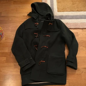 Gloverall mörkgrön duffel - Säljer denna snygga mörkgröna duffeljackan från Gloverall, den är i väldigt fint skick och hur snygg som helst allmänt. Nypris ligger på ca 5000, storleken är 50 och motsvarar passar mig som har M i de flesta plagg. (notera att spännena ser lite mer orangea ut på bilderna, alltså lite brunare i verkligheten). Priset kan diskuteras vid snabb affär!✨