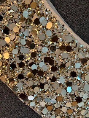 Glittrig kjol med paljetter - Säljer en superglittrig skjorta i guld med stora och små paljetter över hela ytan. Perfekt för att sticka ut och få all uppmärksamhet. Materialet är syntet och  har en ljus bas under paljetterna.
