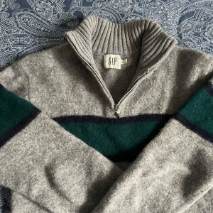 Grå stickad half zip från GAP - Säljer en grå stickad halfzip från GAP. 100 procent shetlandsull och bra skick. Storlek L men tror den kan ha krympt, så är nu mer XS/S