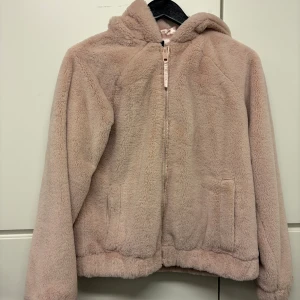 Fluffig pälsjacka i ljusrosa  - Mysig jacka i fluffigt material likt päls. Lite mindre i storlek XS-S