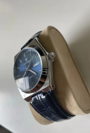 Poedagar quartz 41mm läderband - Snygg klocka från Pedagar med mörkblå urtavla och matchande blått läderband med krokodilstruktur. Boetten är i silverfärgat stål och har en klassisk rund form. Urtavlan har dag- och datumvisning samt tydliga indexmarkeringar. Perfekt accessoar för dig som gillar stilrena detaljer.