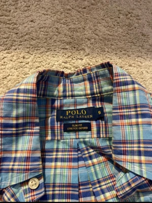 Rutig blå skjorta från Polo Ralph Lauren - Säljer en slim fit stretch oxford skjorta från Polo Ralph Lauren i storlek S. Perfekt för dig som gillar stilrena och färgglada plagg. Pris går att diskutera vid snabb affär!