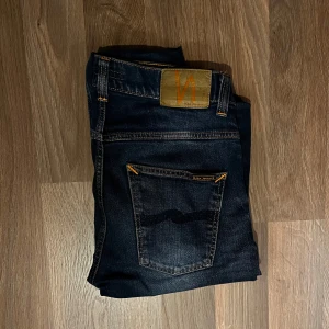 Mörkblå jeans från Nudie Jeans - Ett par Nudies, model Grim Tim i 32,32. Endast använda en gång, då de är för stora för mig. 10/10 skick inget slitage. Aldrig tvättade. Hör av er vid frågor eller funderingar. 