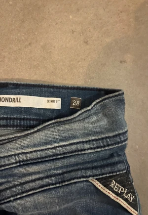 Replay skinny jeans blå 28 - Snygga Replay skinny jeans i mörkblå tvätt med klassiska fem fickor. Jeansens passform är som sagt skinny och de har en tydlig Replay-logga på bakfickan samt läderpatch i midjan. 