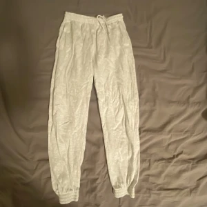 Mjukisbyxor H&M Divided - Grå mjukisbyxor från H&M Divided Basic, storlek S. Byxorna har elastisk midja med snörning och muddar vid bensluten. Dom är i jättebra skick men på bilden är dom lite skrynkliga för dom legat i min garderob ett bra tag. 