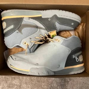 Travis Scott Air trainer 1 sp  - Unika Nike Air Trainer 1 Cactus Corporation sneakers i ljusgrå och beige färg med mesh och syntetmaterial. Snygga detaljer som snörning, rund tå och platt sula. Designen har coola paneler och en modern look som sticker ut. Perfekt för dig som gillar limited edition och streetwear. Endast använda 1 gång!