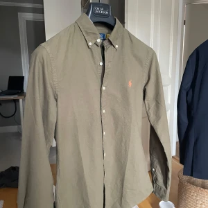 Olivgrön skjorta från Polo Ralph Lauren - Olivgrön skjorta från Polo Ralph. Passar perfekt till sommaren!! Nyskick, använd endast 1 gång. Slim fit. Nypris: 1795kr. Mitt pris: 300kr!!!! Hör av er vid frågor! Pris ej hugget i sten!! Mvh Ebbe 🤗