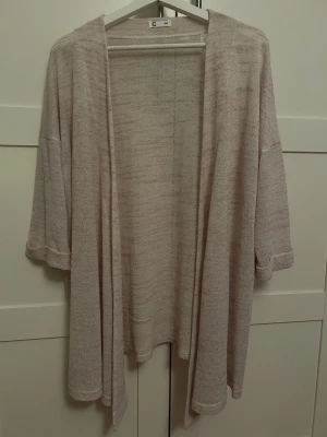 Beige kofta från Cubus strl. XS/S - Luftig och mjuk beige kofta från Cubus med trekvartsärmar. Perfekt för lager på lager och enkel att matcha till olika outfits. Materialet känns lätt och skönt mot huden.