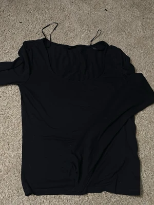 Mörkblå långärmad topp från Gina Tricot - Mörkblå långärmad topp från Gina Tricot. Slits i ärmarna längs ned, bra skick 