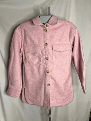 Ljusros overshirt från H&M, XS Oanvänd - Snygg rosa overshirt från H&M i storlek XS. Jackan har klassisk krage, två bröstfickor med lock och stora knappar framtill. Perfekt lager-på-lager-plagg med lång ärm och avslappnad passform.