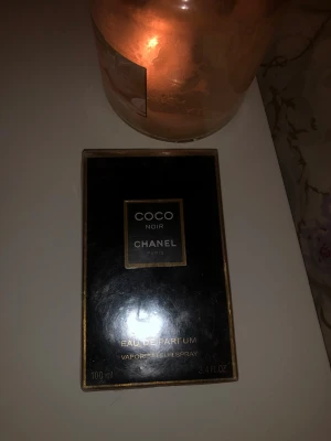Coco Noir Eau de Parfum 100ml - Snygg och lyxig parfym från Chanel, Coco Noir Eau de Parfum. Förpackningen är på 100 ml och kommer i en stilren svart och guldig box. Perfekt för dig som vill ha något exklusivt i din samling.