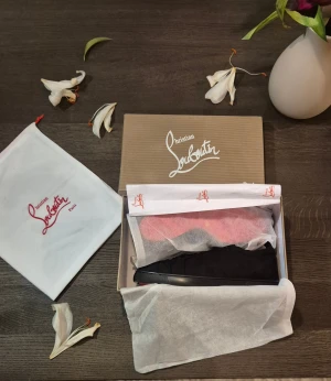 Christian Louboutin svarta  - Snygga svarta sneakers från Christian Louboutin i mocka med klassisk röd sula. Skorna har rund tå, svarta skosnören och diskret branding på insidan. Kommer med originalkartong och dustbag. Perfekta för dig som vill ha en lyxig och stilren look.