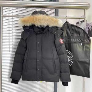 Svart dunjacka från Canada Goose - Säljer en svart dunjacka från Canada Goose med stor huva och fluffig pälsdetalj. Jackan har klassisk patch på ärmen, raka fickor och stängs med både dragkedja och knappar. Perfekt för kalla vinterdagar och riktigt snygg streetstil.