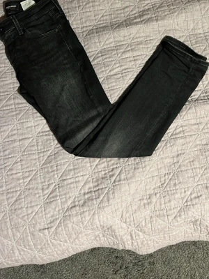 Svarta jeans från Jack & Jones - Snygga svarta Slim glen jeans från Jack & Jones med diskret tvättad look. Modellen har klassisk femficksdesign, smal passform och raka ben. Jeansen är tillverkade i stretchig bomull för extra komfort och har dragkedja i gylfen.