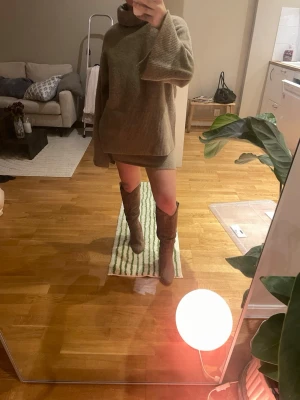 Beige stickat set från Lojsan x NA-KD - Säljer en oversized beige polotröja och tillhörande kjol från Lojsan x NA-KD. Tröjan är stickad i mjukt material med breda, långa ärmar och ribbade detaljer vid hals och nederkant som matchar kjolen. Perfekt för lager-på-lager och chill höst- och vinterstil. Står Strl XS men är mer en S🤗