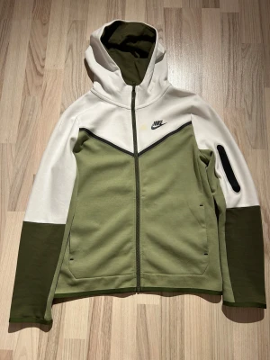 nike tech fleece - En skön nike tech fleece i grön o vid med en svart dragkedja 