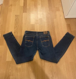  Nudie Jeans Herr - Snygga mörkblå jeans från Nudie Jeans i modellen skinny med klassisk femficksdesign och orangea sömmar. Jeansen har en normal passform och är tillverkade i mjukt denimtyg. Bakfickorna har Nudie Jeans signaturbroderi och läderpatch i midjan. Priset är inte hugget i sten vid snabb affär, skicka alltid vid frågor.😄