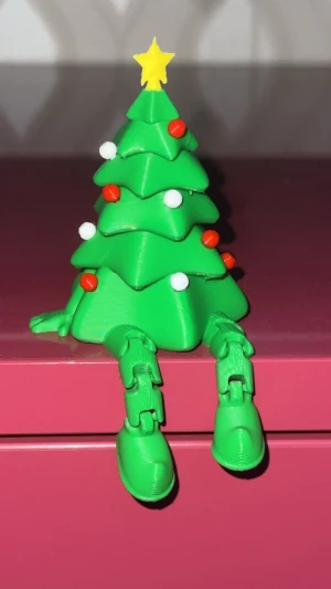 3D-Printad Flexibel Julgran - En väldigt unik decoration som blir både en leksak samt en decor till rummet. Den har både händer och fötter, fötterna är flexibla så de passar vilken bord/hylla som helst. Färgerna på röda och vita pyntarna går att ändras på.