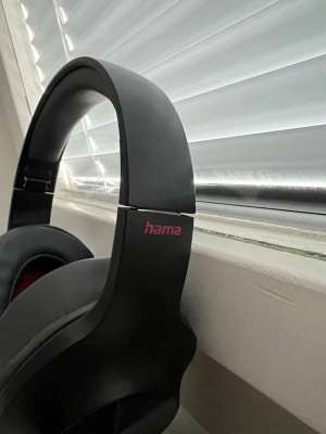 Hama Over-Ear Hörlurar - Bekväma over-ear hörlurar från Hama med mjuka kuddar och justerbar bygel. Utrustade med röda kablar för USB och 3,5mm anslutning. Hörlurarna är vikbara för enkel transport och visar inga synliga defekter eller slitage. Perfekt för musik, spel eller arbete.