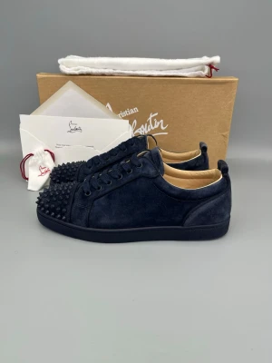 Christian Louboutin Louis Junior Spikes Sneaker Navy - • The shoes have been gently used and are in very good condition  • Size: 42.5 (fits 43–43.5)  • Color: Navy / Dark Blue  • Retail price: 9500 SEK / 795€  • Box, dustbag, extra spikes & card from retailer