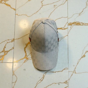 Ljusblå designer keps - Säljer en snygg ljusblå keps med diskret GG-mönster över hela kepsen och klassiska ränder i grönt och rött på sidan. Kepsen har böjd skärm och justerbar passform. Perfekt för dig som gillar stilrena accessoarer med lyxig känsla.