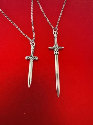 Silverhalsband x2 svärd  - Halsband skapat av mig och dottern.  Halsband som inte är i äkta silver/guld. Kedja är oftast 50cm men kan ibland komma i 45cm. Kedja är rostfritt stål, berlock oftast i zinklegering men kan även det i vissa fall vara rostfritt stål. Be gärna om mått på berlock om detta är viktigt då bilderna är missvisande när det gäller hur stora dom är! 🌹❤️  Allt är nytt även om de kan stå ”mycket bra skick” , detta mest för att Vinted inte ska fundera på varför jag bara har nya saker .  Bud accepteras inte 🥰🌹