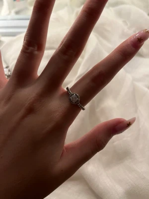 Ingen väst på bilderna - Bilderna visar smycken, bland annat en silverring med en rund sten och två armband som är från Pandora skriv om några frågor priset kan diskuteras.