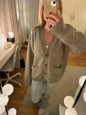 Stickad kofta i ull blandning  - Mysig beige stickad kofta med v-ringning och fyra knappar framtill. Så snygg!!