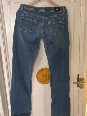 Blå jeans från LTB med bootcut - Säljer ett par klassiska blå jeans från LTB med bootcut-snitt low waist. Materialet är jeans och de har en snygg faded effekt framtill. Perfekta för dig som gillar en avslappnad stil.
