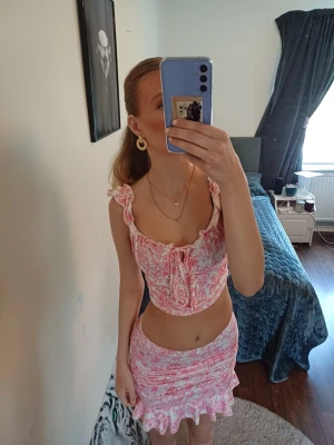 Rosa blommig linnetopp o tjol  - Supersöt set med  linnetopp i vitt och rosa med blommigt mönster o tjolen. Toppen har volangdetaljer vid axelbanden och en söt knytning framtill.  Perfekt för varma dagar och somriga vibes. Skriv för med bilder eller frågor ❤️ 