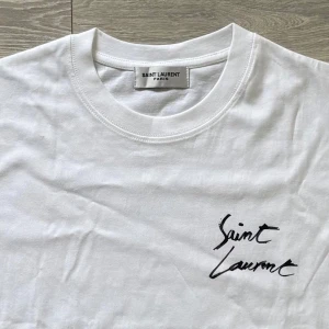 Saint Laurent t-shirt - Ny och Oanvänd vit t-shirt från Saint Laurent med logotyp-tryck både fram och bak. Perfekt för dig som vill ha en snygg look! Kom med frågor!😁