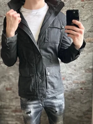 Svart vindjacka från j.Lindberg - Ok skick, knappar saknas och rätt använd. Storlek S passar dig som är mellan 175-185cm ungefär. Nypris ca 4000kr. Modellen är 185 cm, 79 kg. Foreman heter modellen. Passar bra nu till vintern. Skriv för mer information!🤝