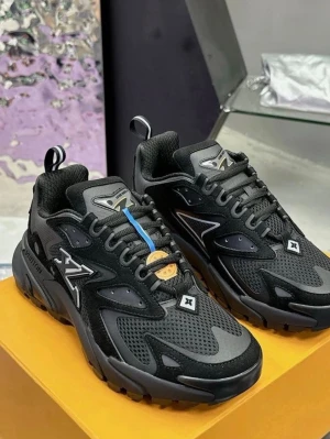 Louis Vuitton svarta sneakers - Svarta Louis Vuitton sneakers med chunky sula och LV-logga på sidan. Skorna har mesh och mockadetaljer, snörning och coola paneler i olika nyanser av svart och grått. Perfekt för dig som vill ha en lyxig och sportig look med streetkänsla.