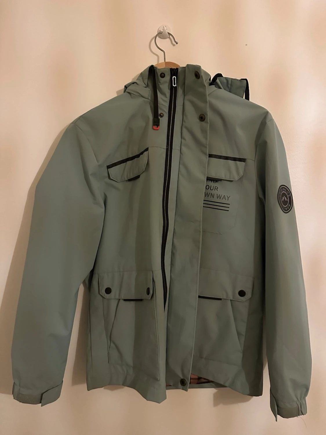 Grön vindjacka med rutig huva